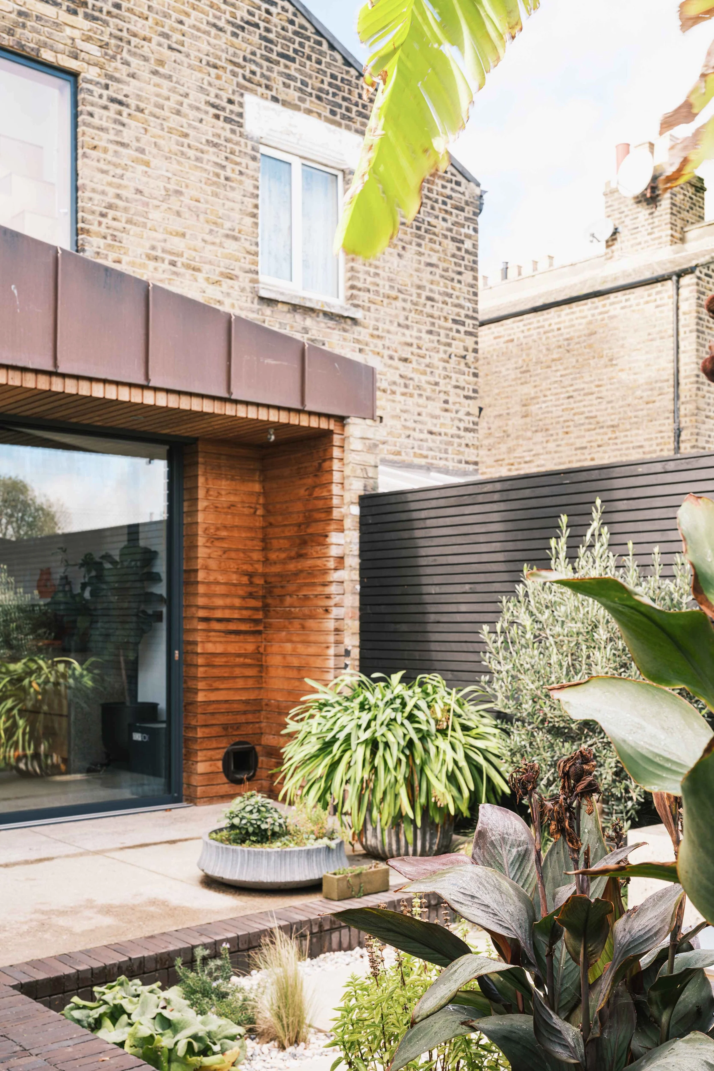 Copper extension with deep overhang and lush garden design