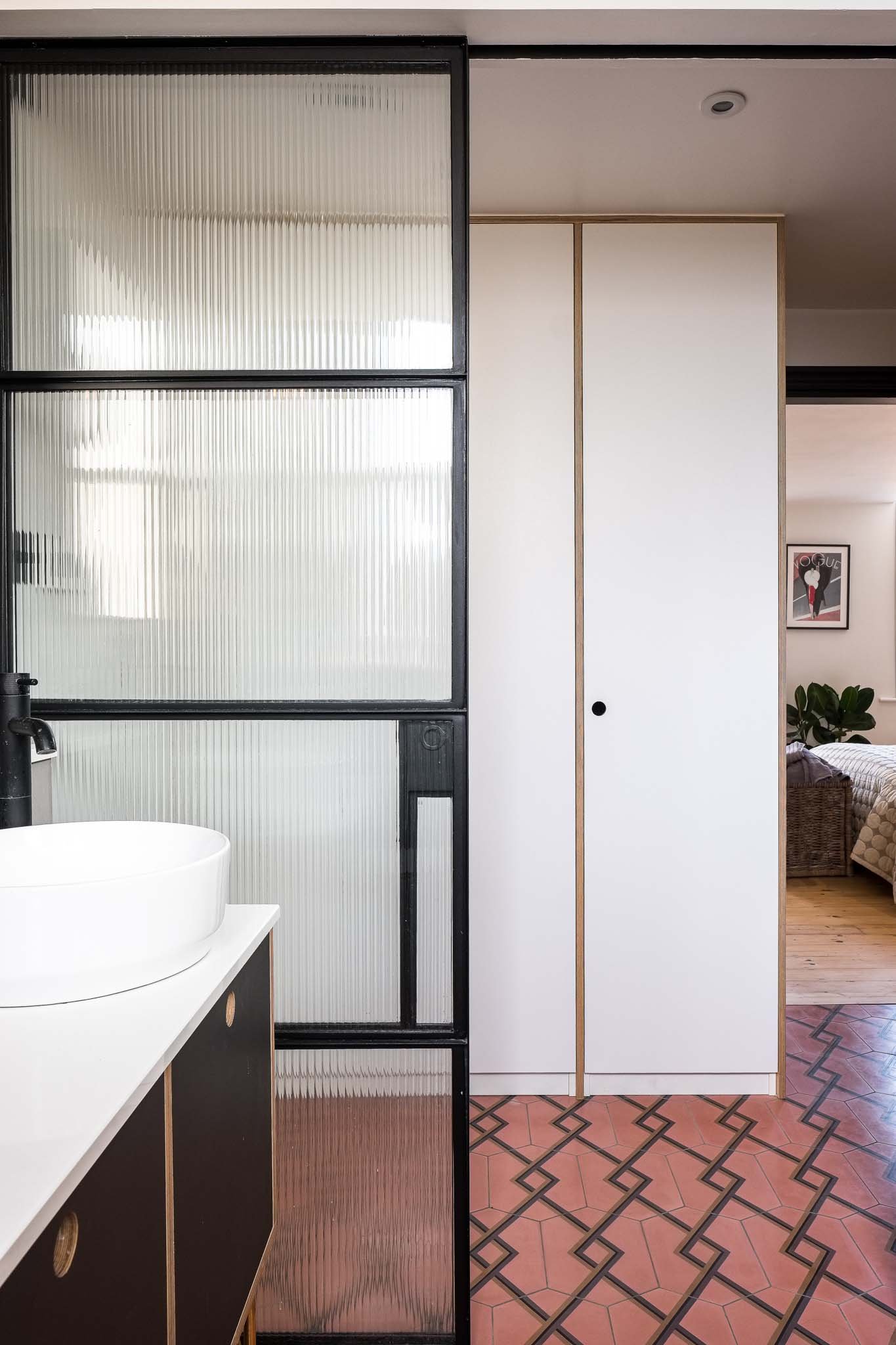 Crittall door in ensuite with plywood joinery and pink tiles