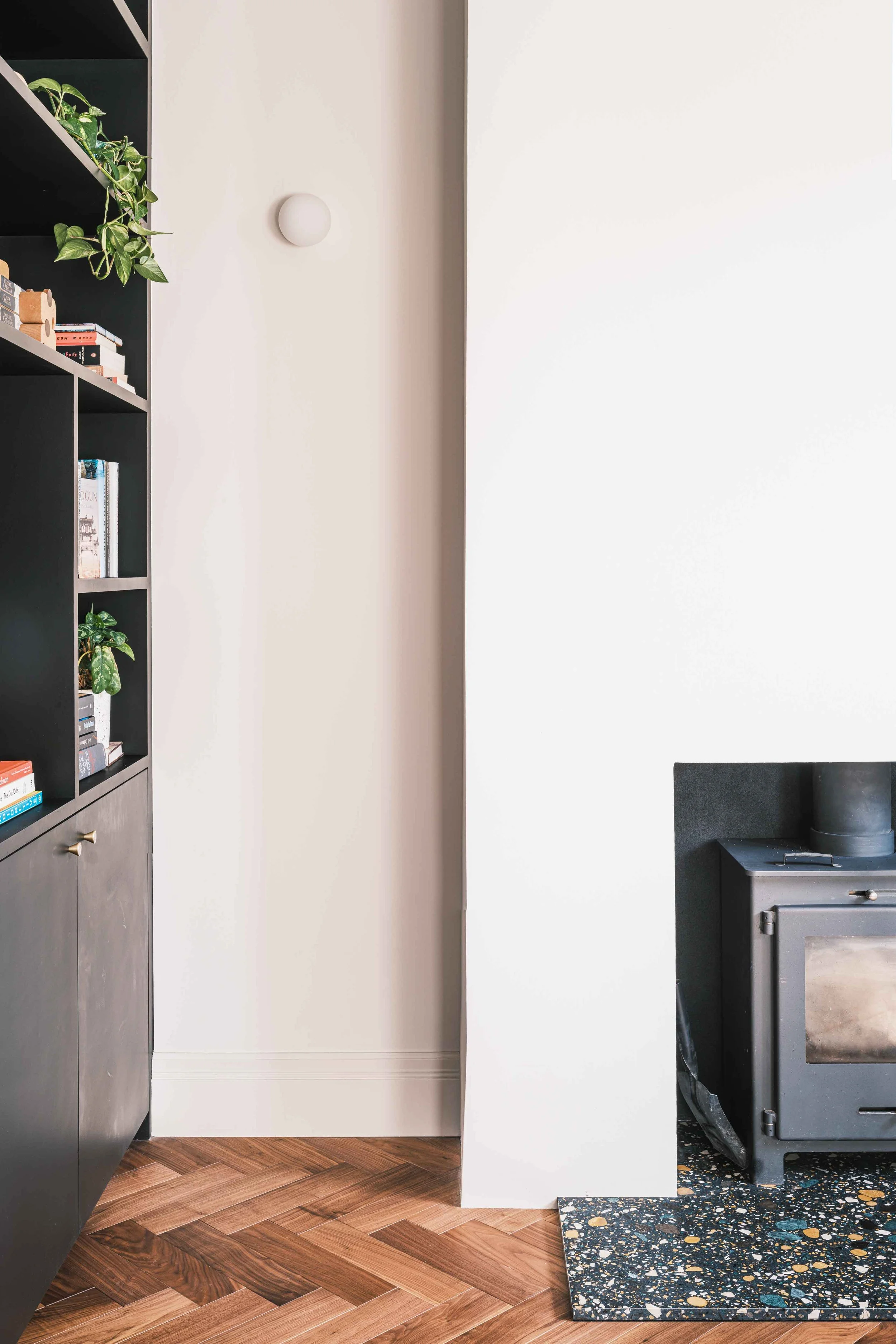 Walnut herringbone floor with terrazzo hearth