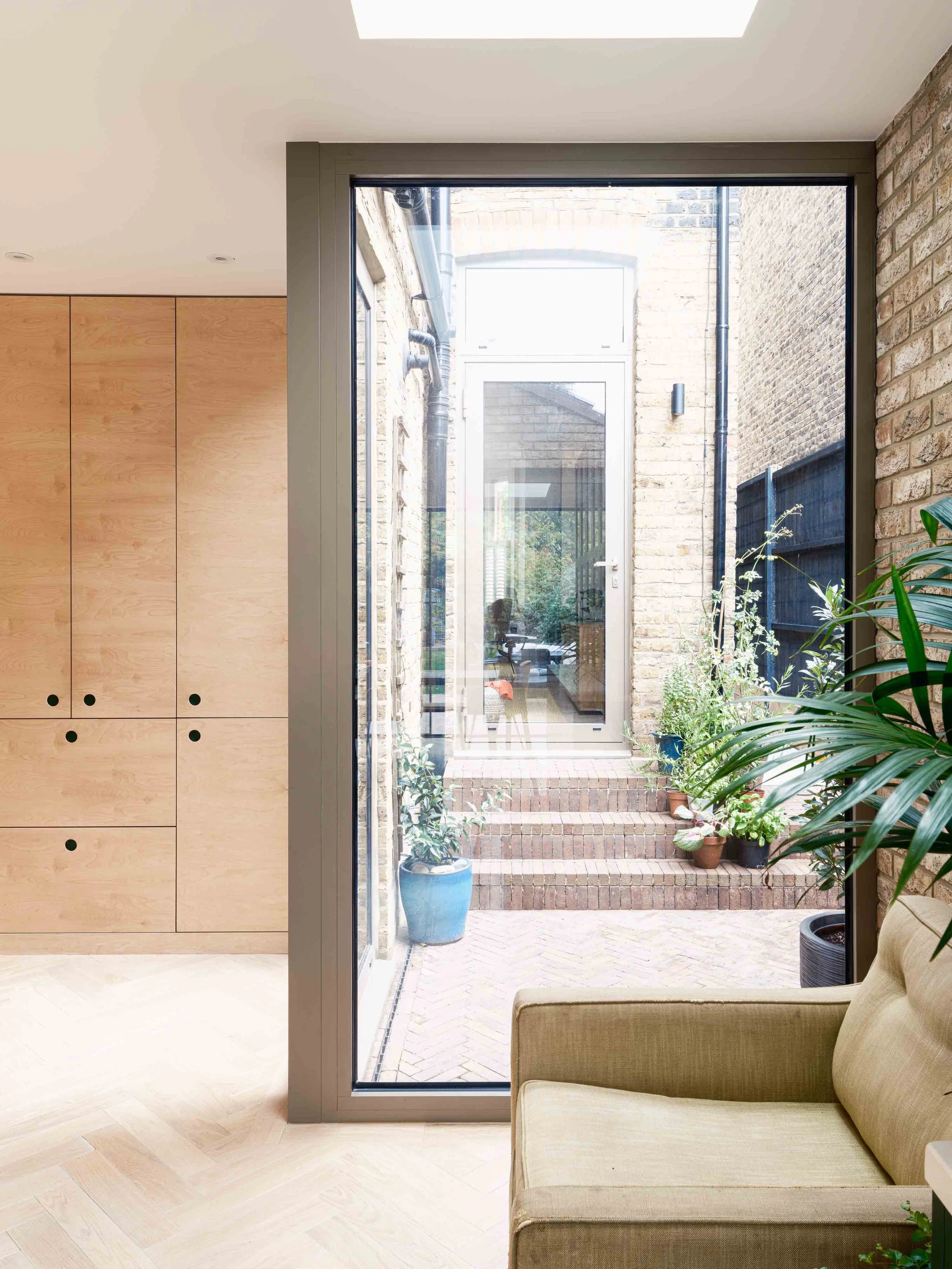 Courtyard corner window with pale oak floor and plywood cupboards