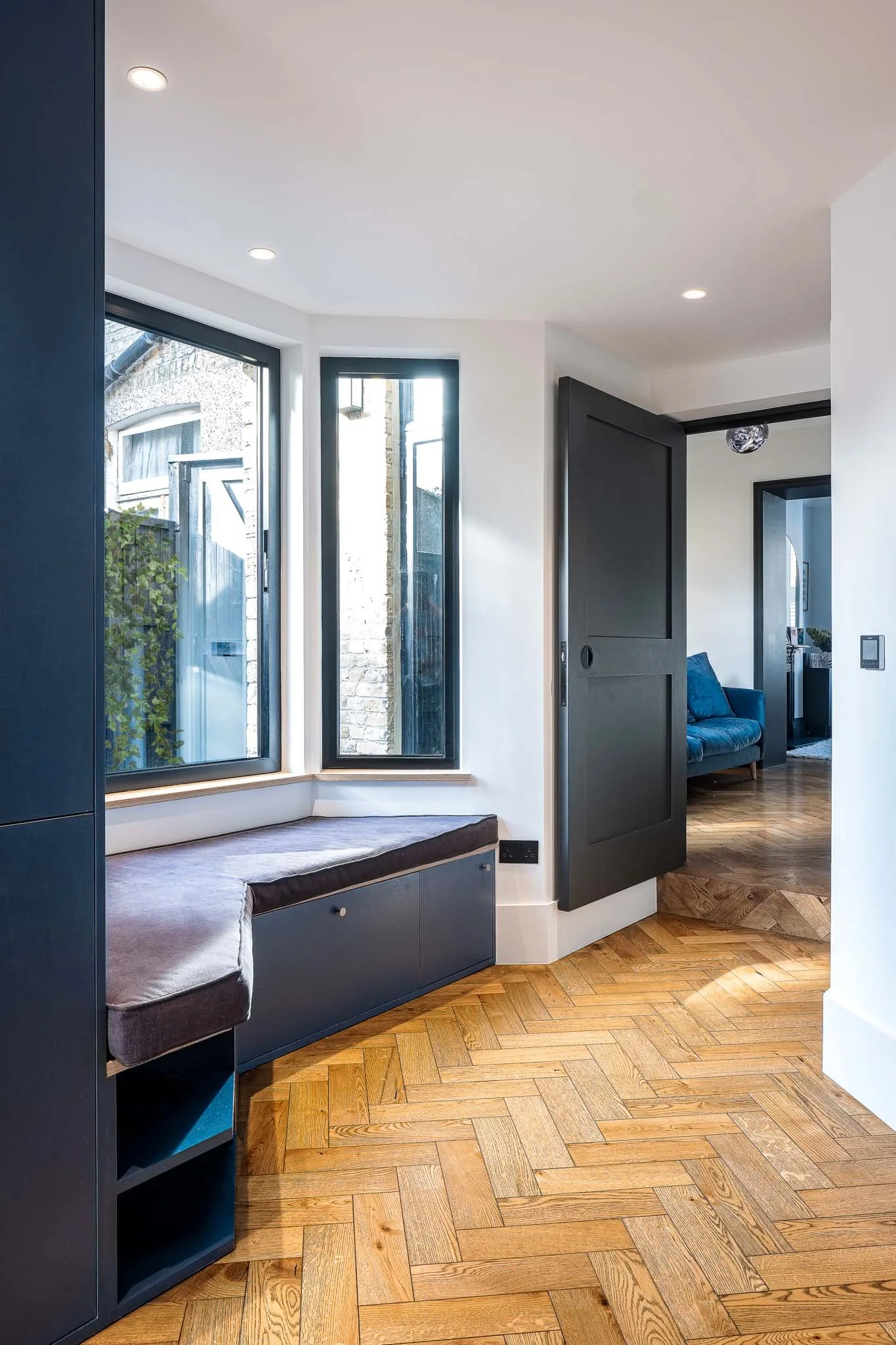 Window seat and pivot door linking living spaces