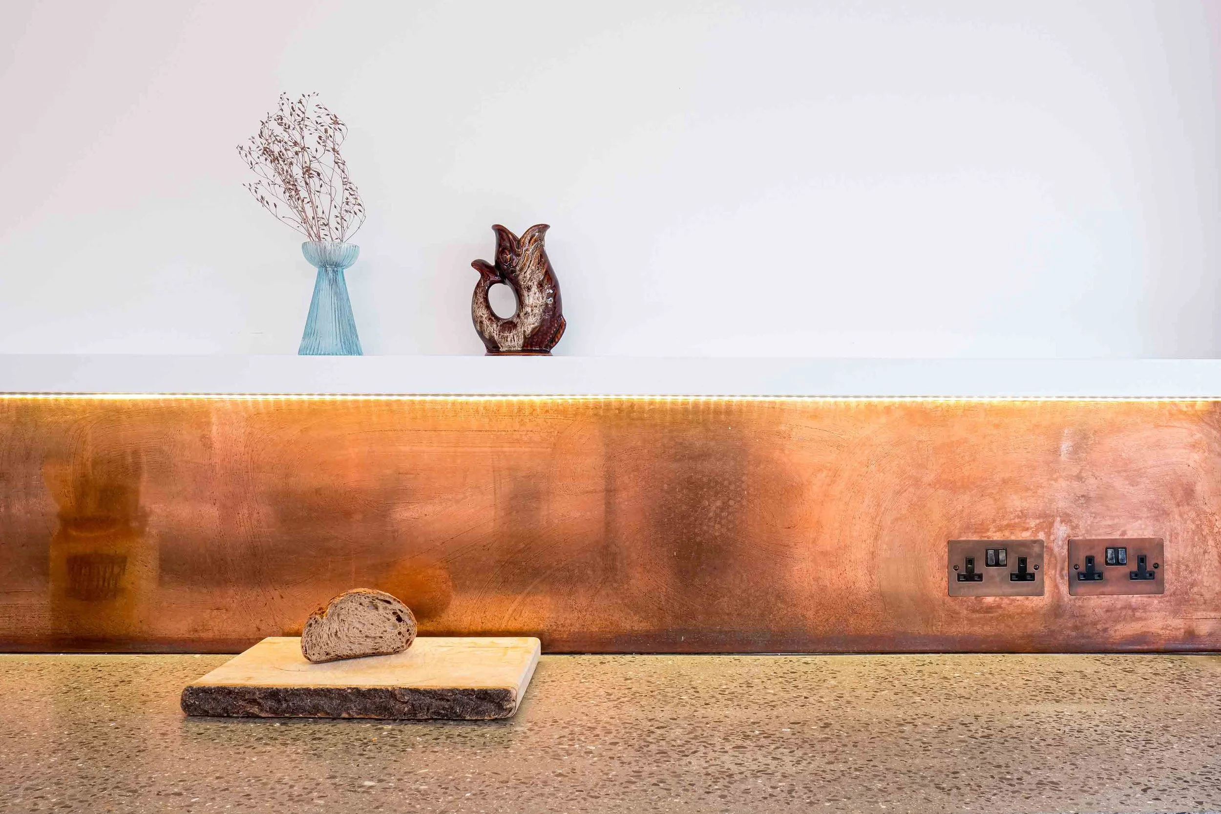 Copper splashback with polished concrete worktop