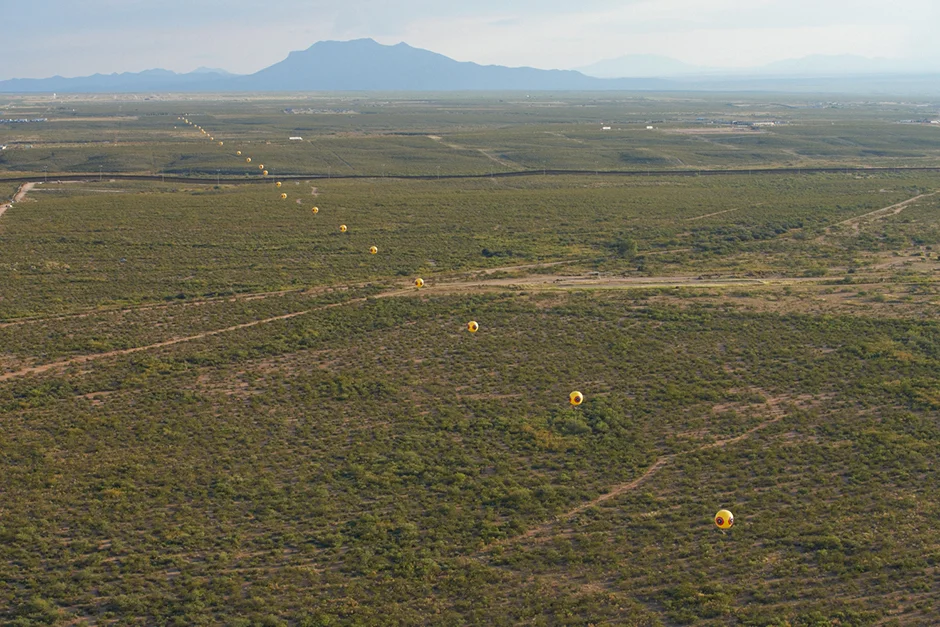 Postcommodity, Repellent Fence (2015), land art installation and community engagement (Earth, cinder block, para-cord, pvc spheres, helium). Installation view, US/Mexico Border, Douglas, Arizona / Agua Prieta, Sonora. Image Michael Lundgren, courtesy of Postcommodity.