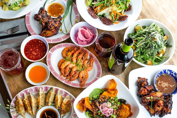 Variety of food on wooden table to Hey Hey Canteen