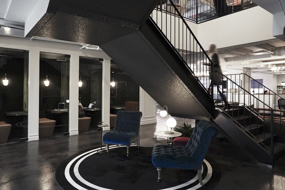 business man climbing large staircase at Bond Collective shared office space building