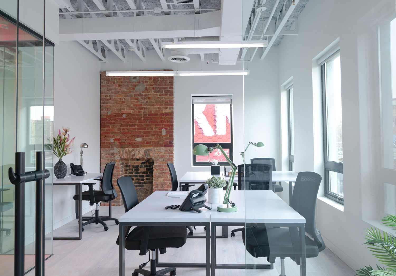 white and brick office area with large tables and chairs