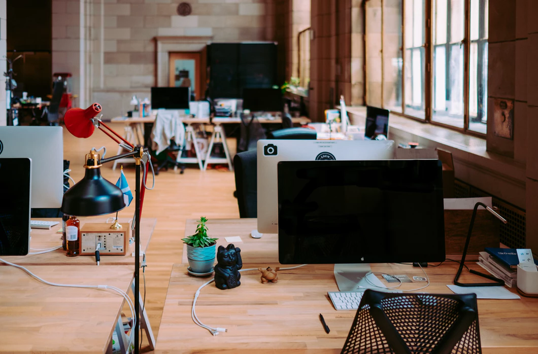 desks with computers grouped together in one area of an open office plan
