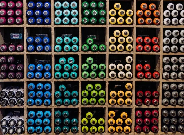 bottles of colored paint organized in cubbies