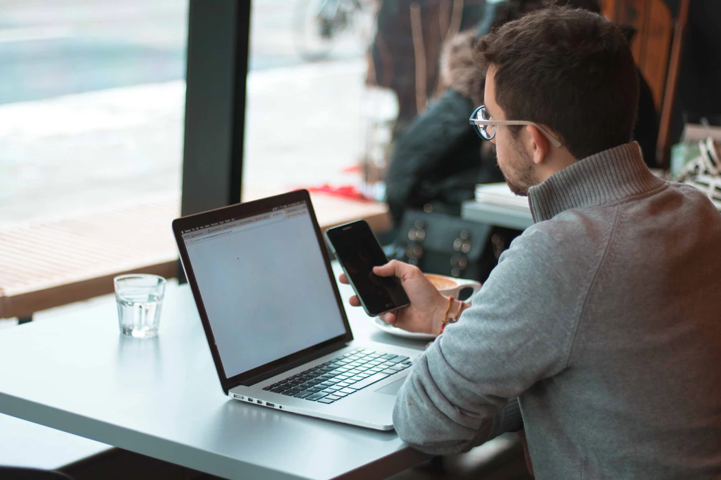 solopreneur using his laptop and mobile phone to work in a cafe