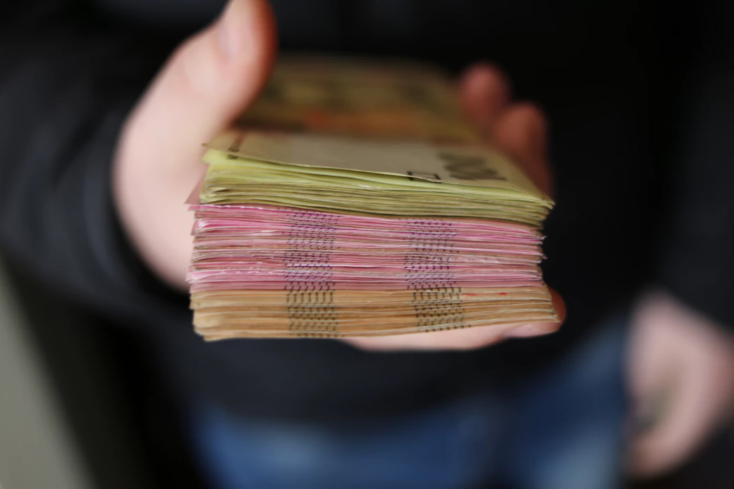 hand holding stack of currency