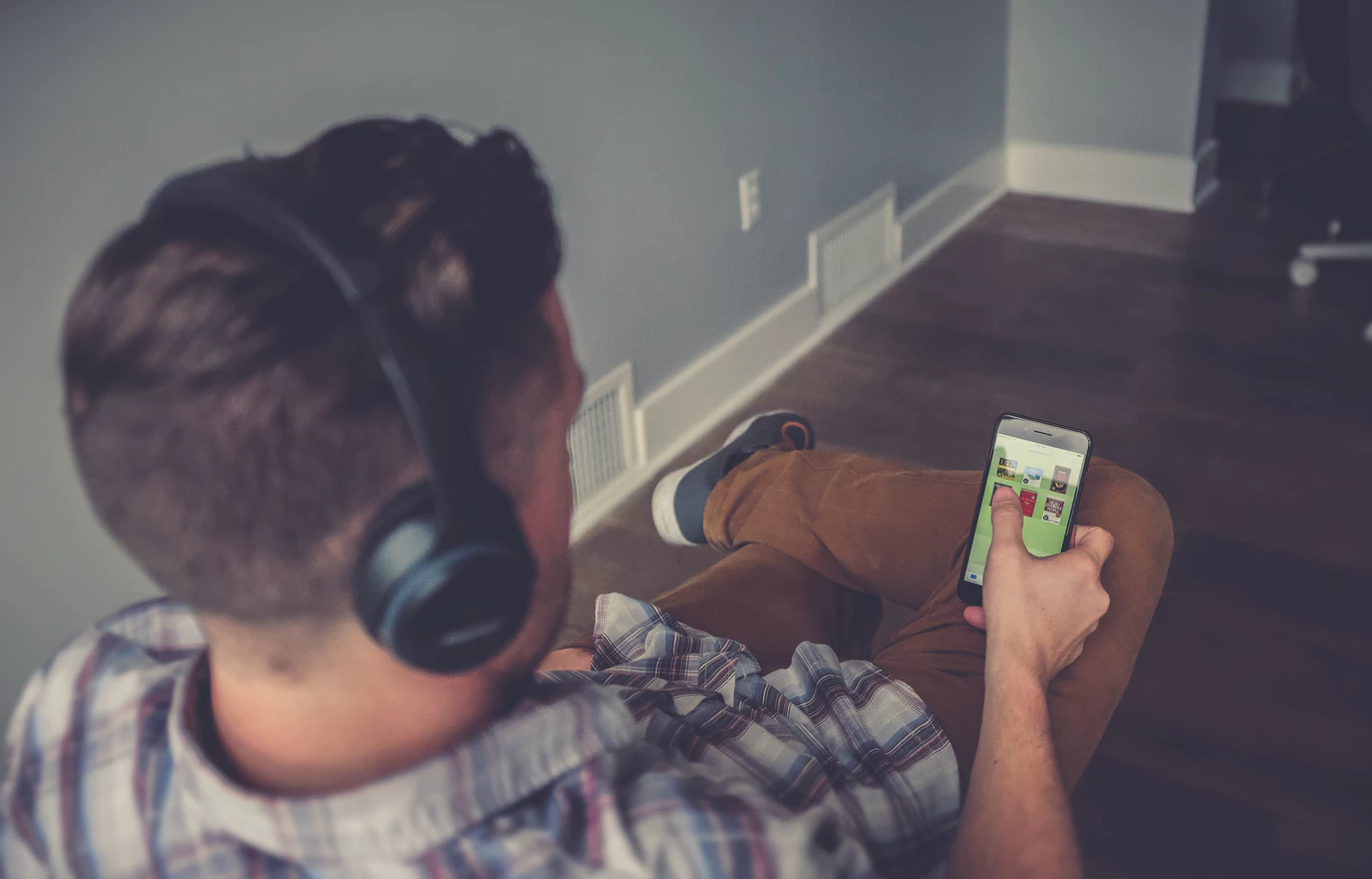 digital nomad selecting from the best entrepreneur podcasts on his phone