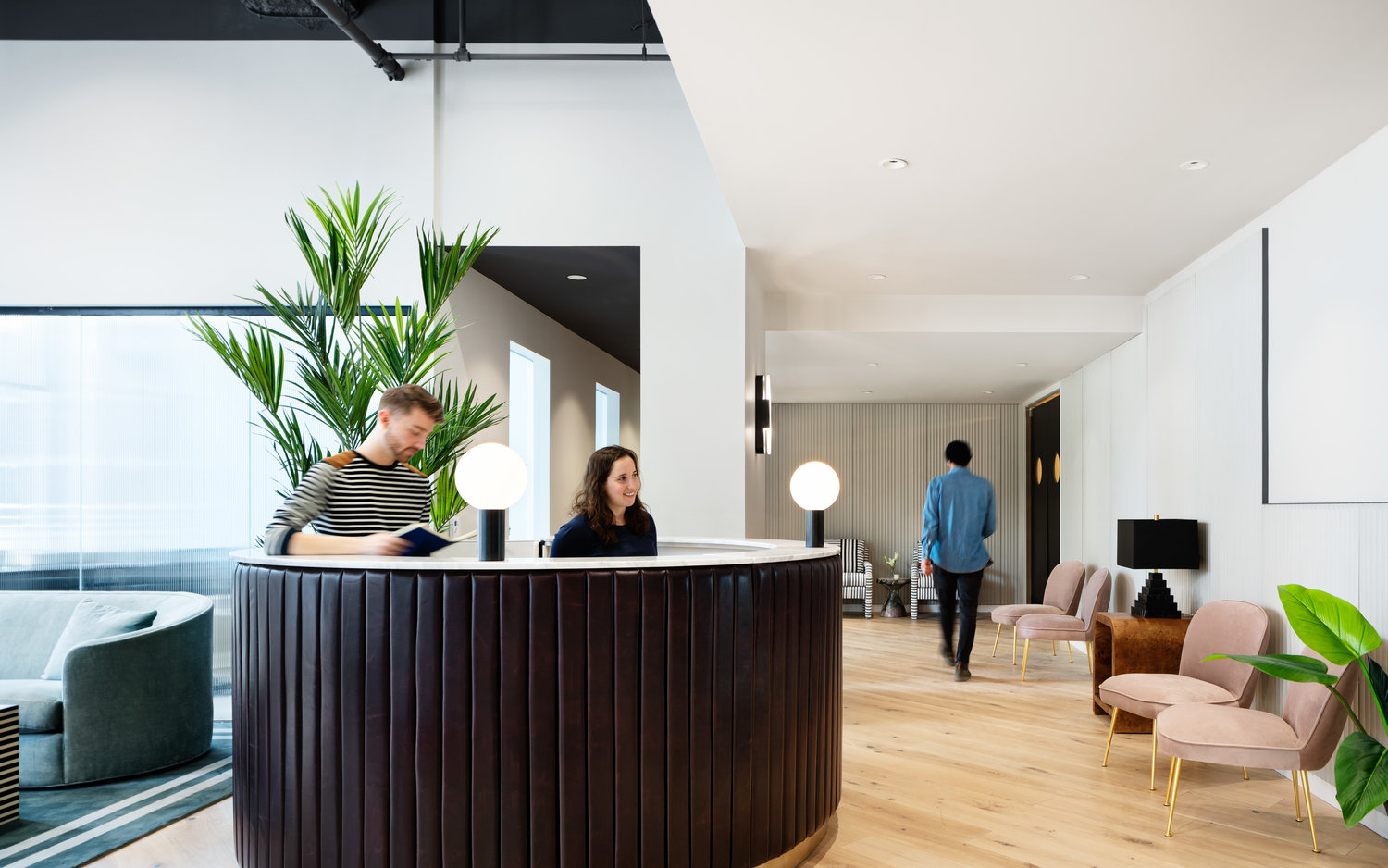 Man and woman working the desk at a Bond Collective location