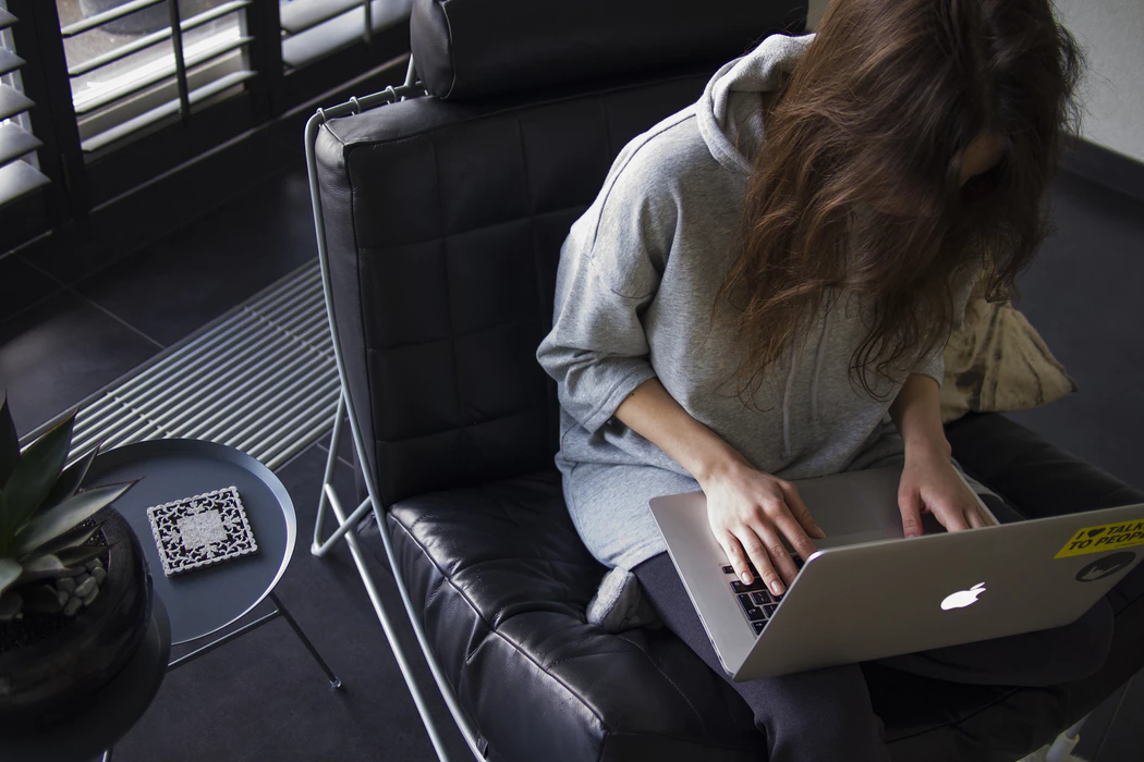 woman using laptop after weighing pros and cons of working from home
