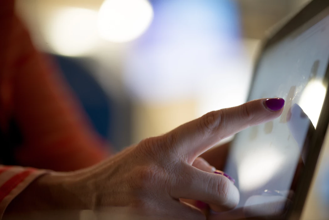 Woman using technology in the workplace while touching a screen