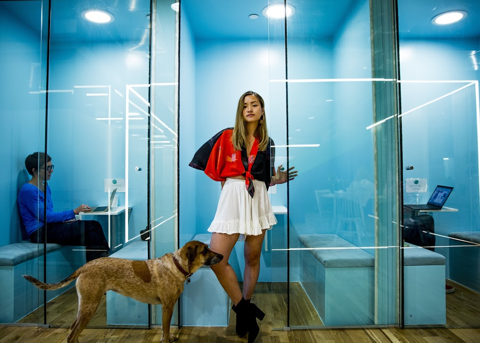 Woman standing in an office in front of a pet