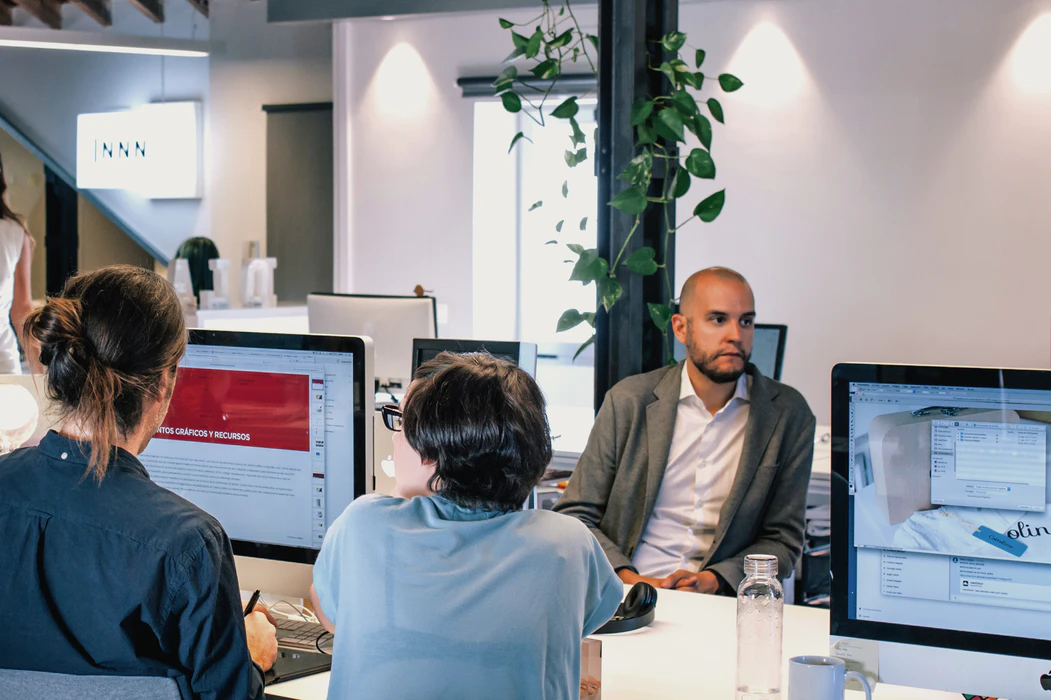 Professionals sitting in front of computers discussing what is a startup