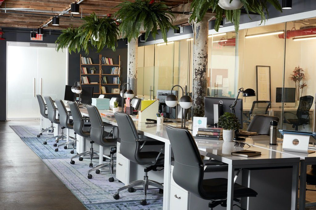 Open office space with row of chairs in front of a long white table