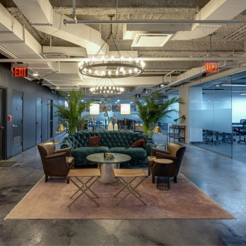 nicely furnished startup office space with comfy couch and large chandelier