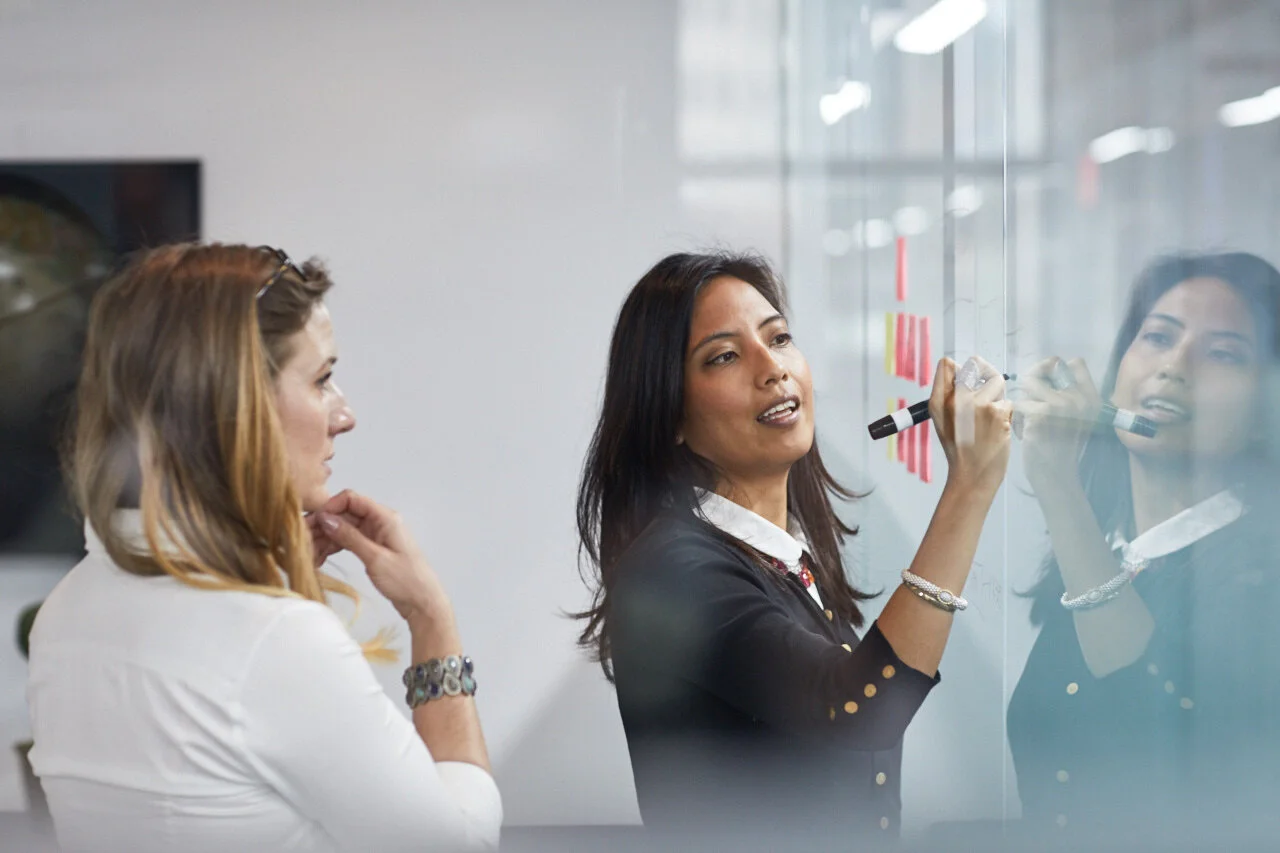 Two women discussing how to reduce costs in their start up