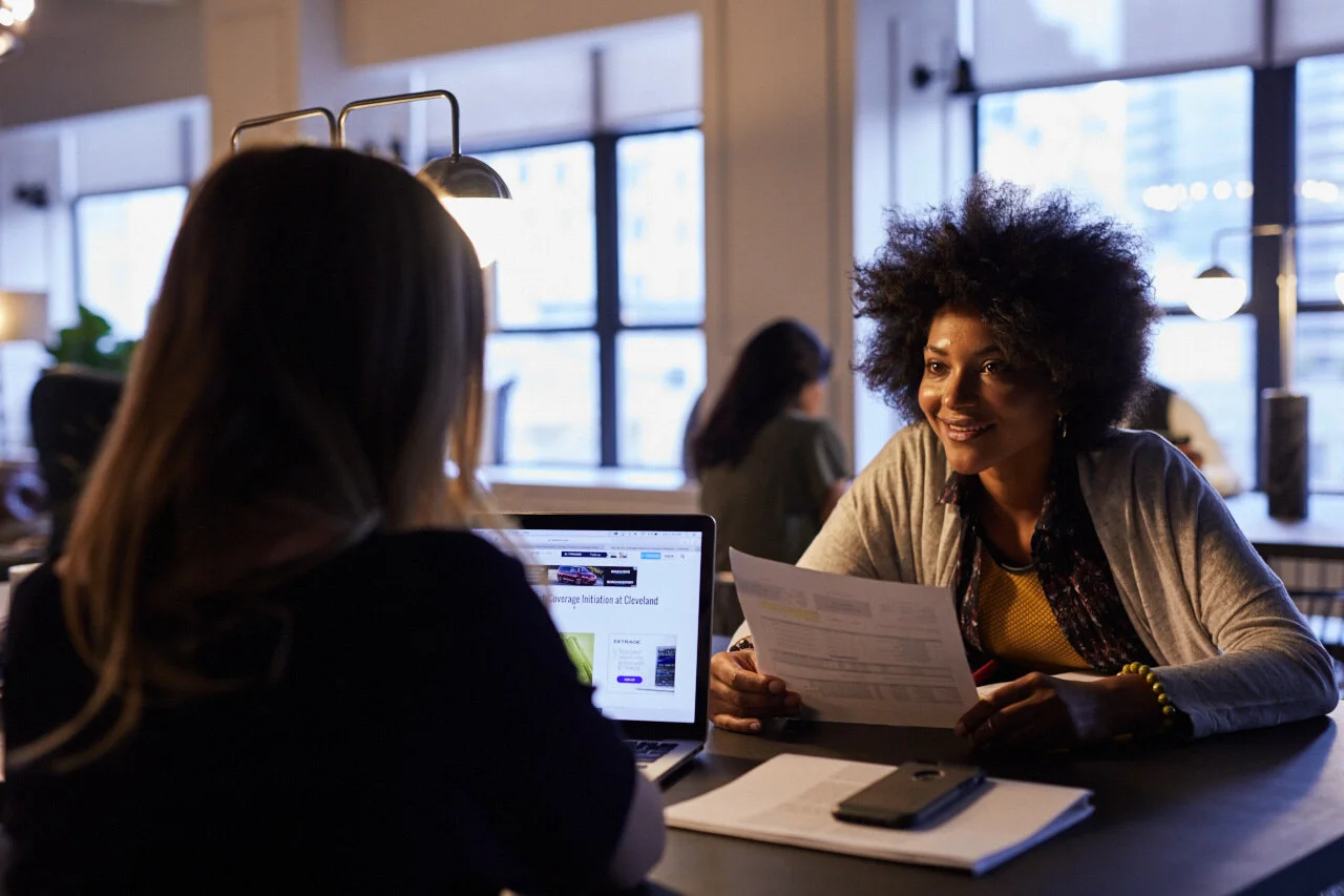 Tw employees hoteling a desk together