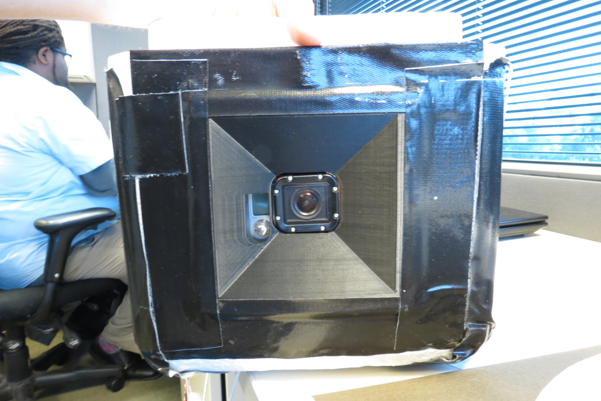 3D printed camera holder, glued and taped into side of foam cooler.