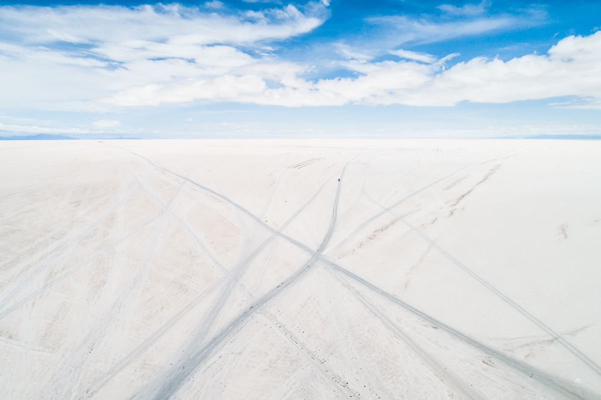 blue-white-salar-de-uyuni-salt-flats-potosi-bolivia-car-tracks-vast-expanse-desert-vastness-jeep-4x4-wheel-drive-road-roadtrip-south-america.jpg