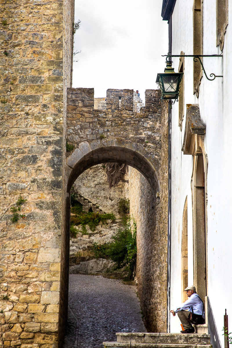 obidos-portugal-medieval-city-man-sitting-doorstep-street-photography-trip-tour-photographer.jpg