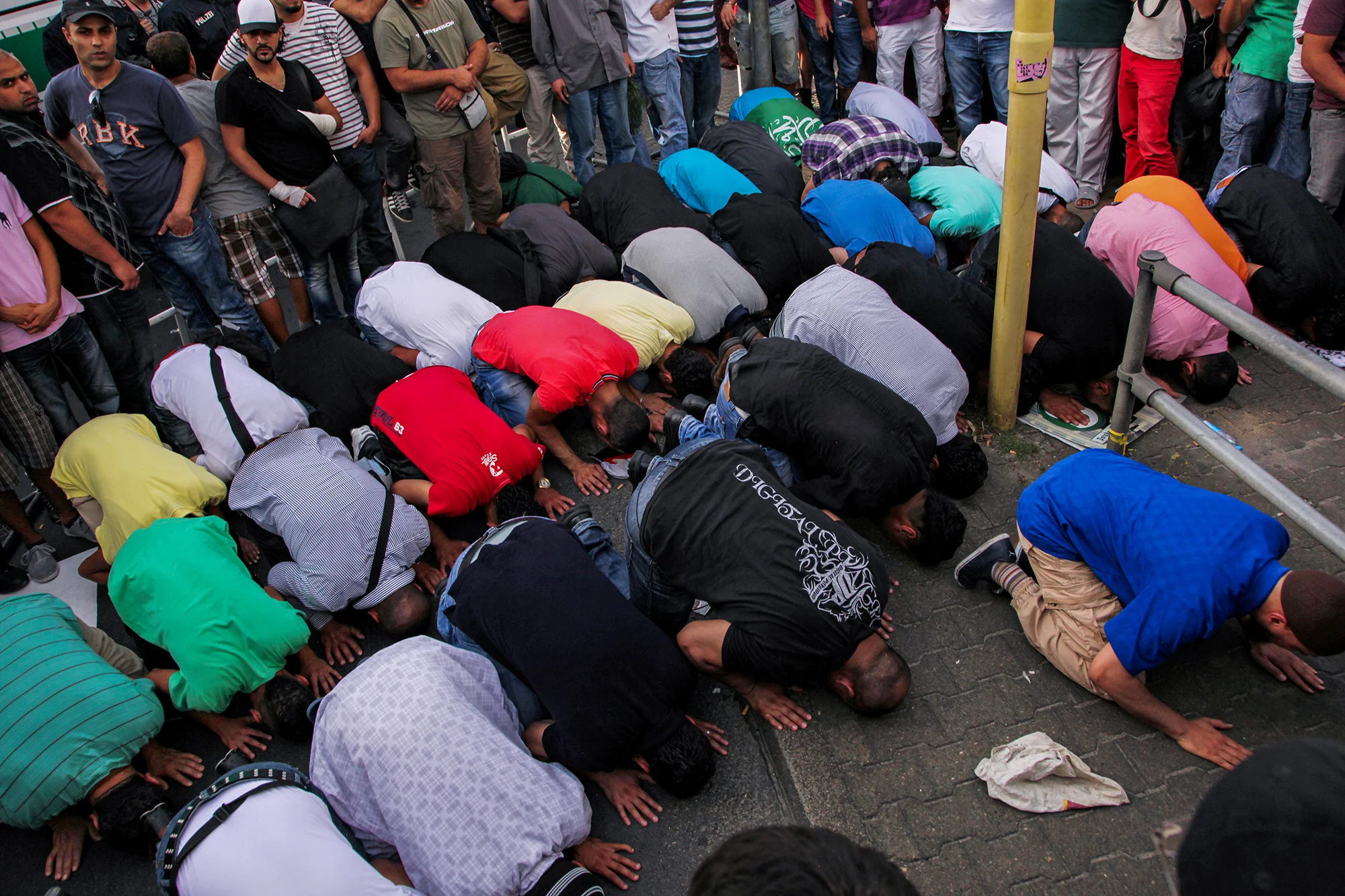 A group of young Muslim men pray together on the streets of Neukölln. A mark of solidarity and protest towards the "Pro Deutschland" group and their "anti-Islamisation of Europe" demonstration that took place at several location in Berlin that day, 2012.