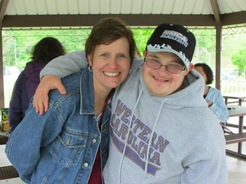 David (right) puts his arm around his mom Becky (left) and they both smile for a picture.