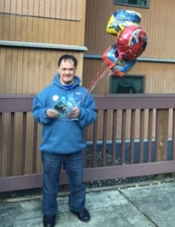 TK stands in front of his apartment with balloons.jpg