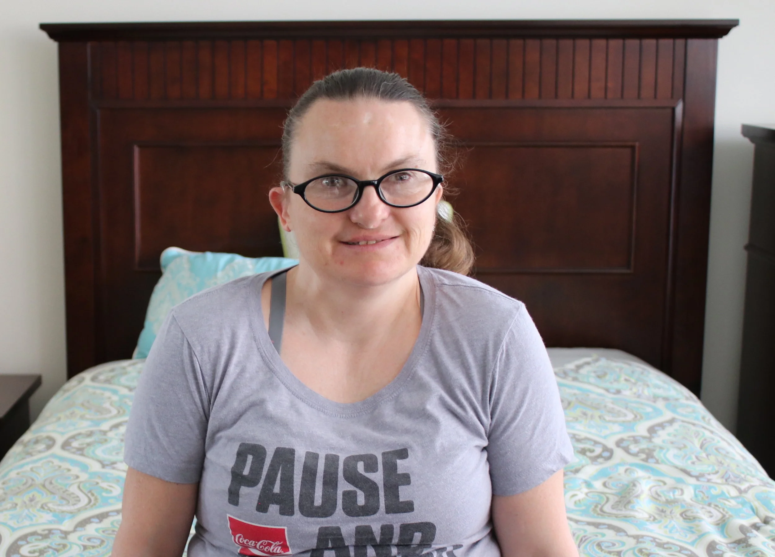  Colleen sits in the bedroom of her new place. 