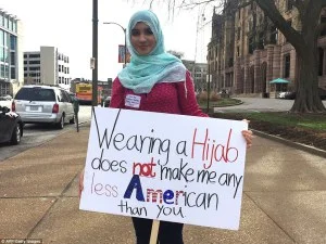 Woman holding a sign in protest after a rally for Donald Trump in St. Louis, Missouri (March 2016).