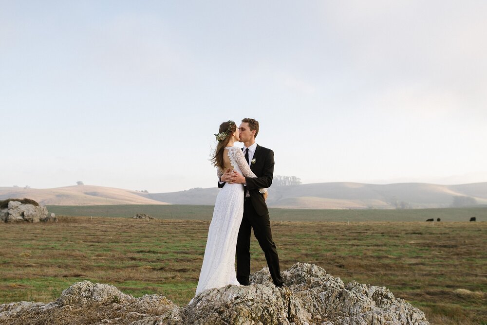 bride and groom kissing looking over stemple creek ranch