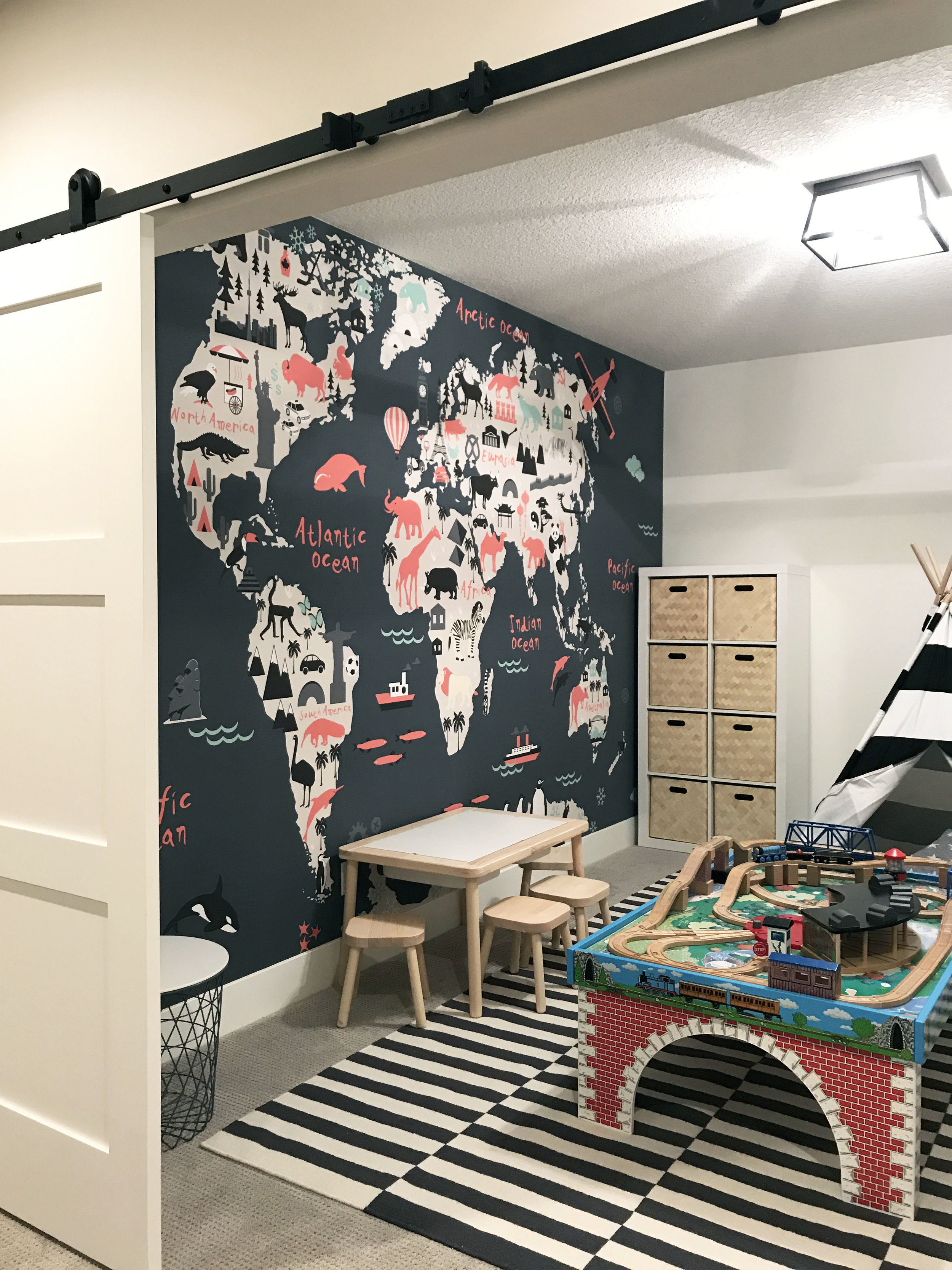 Kids playroom with wall to wall, floor to ceiling map of the world. Interior Furnishings by Nyla Free Designs, Build by Veranda Estate Homes