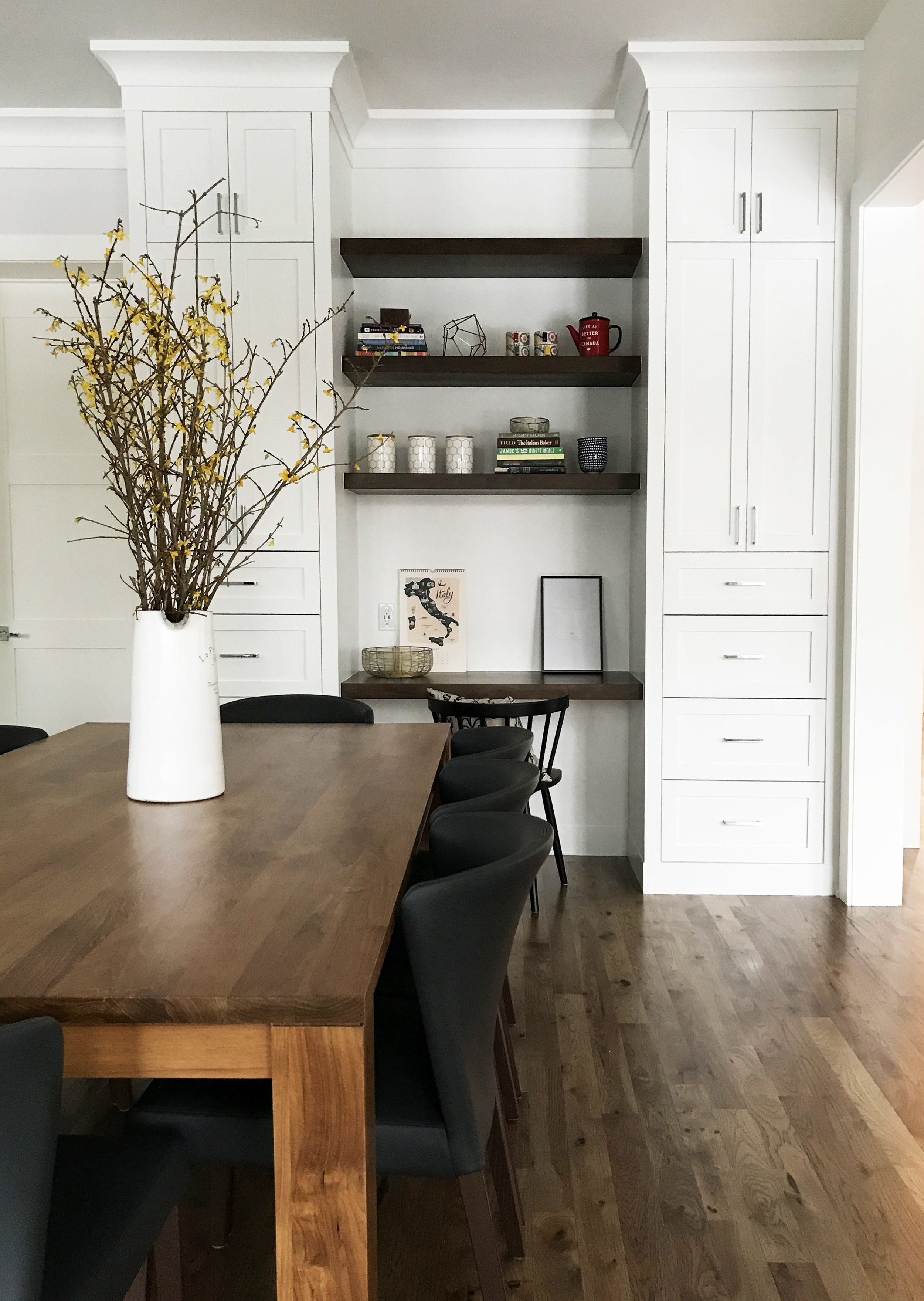 White kitchen with honed counters and warm wood accents. Interior Furnishings by Nyla Free Designs, Build by Veranda Estate Homes