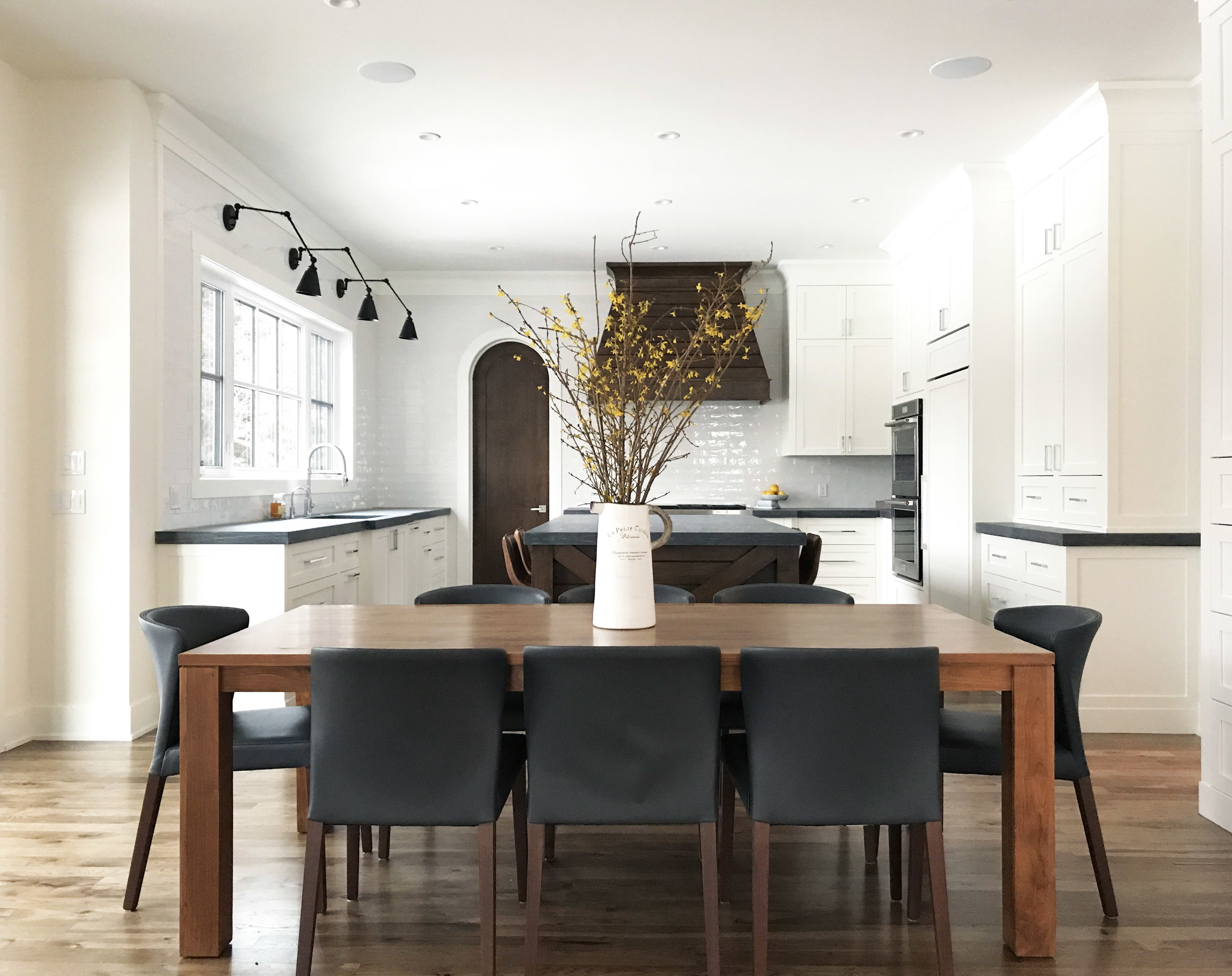 White kitchen with honed counters and warm wood accents. Interior Furnishings by Nyla Free Designs, Build by Veranda Estate Homes