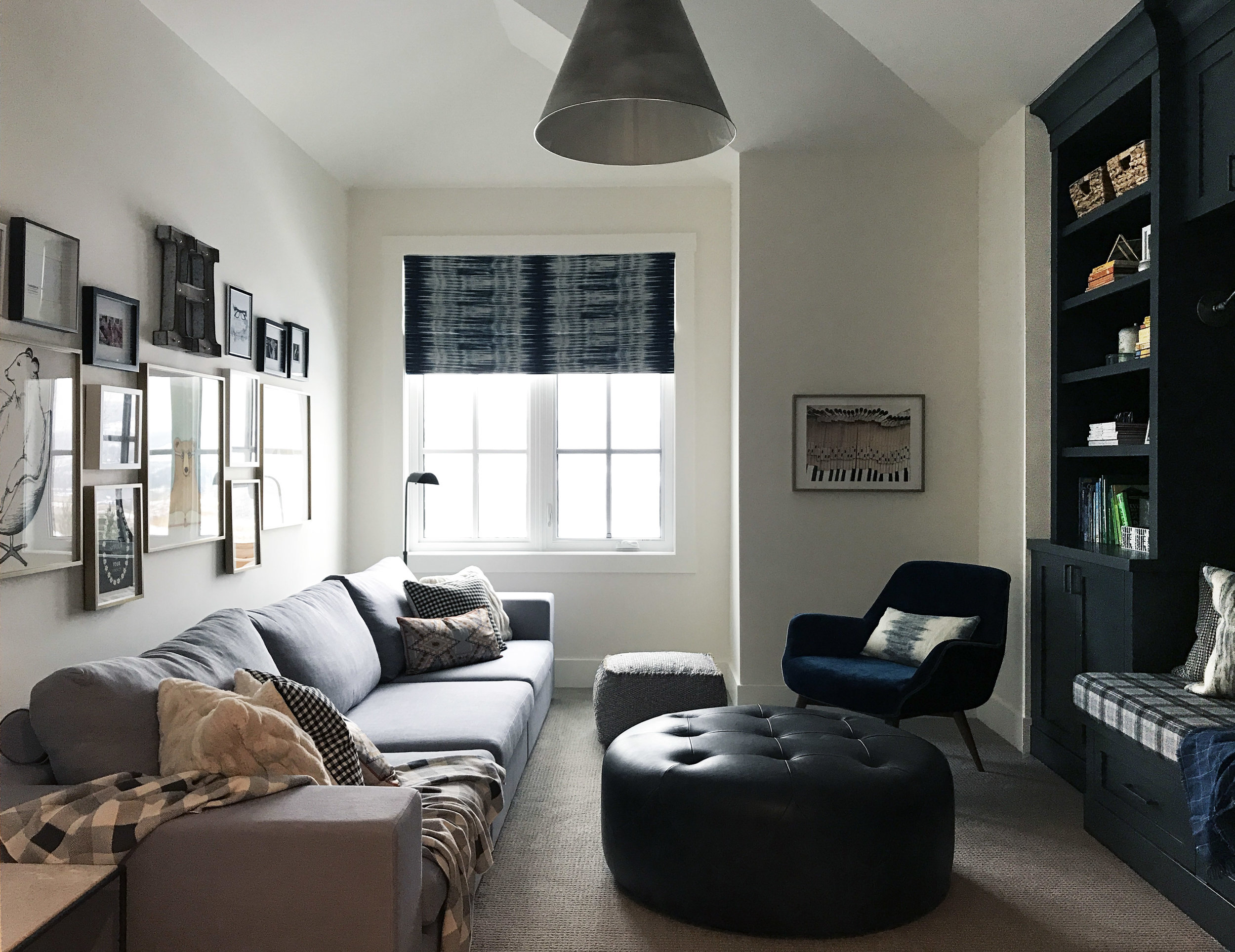 Family reading room with extra long sectional, gallery wall and wall to wall built-in storage. Interior Furnishings by Nyla Free Designs, Build by Veranda Estate Homes
