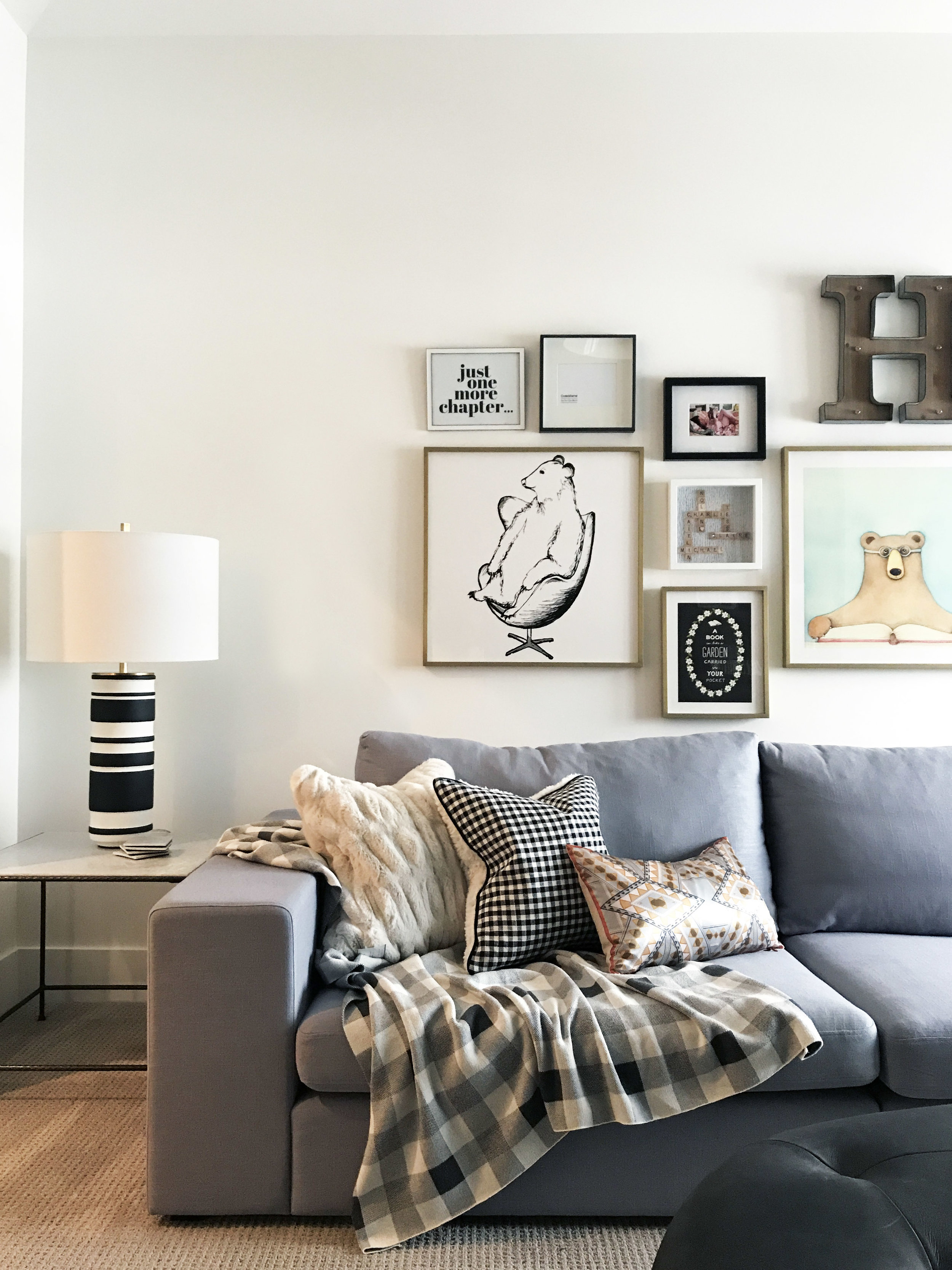 Family reading room with extra long sectional and gallery wall. Interior Furnishings by Nyla Free Designs, Build by Veranda Estate Homes