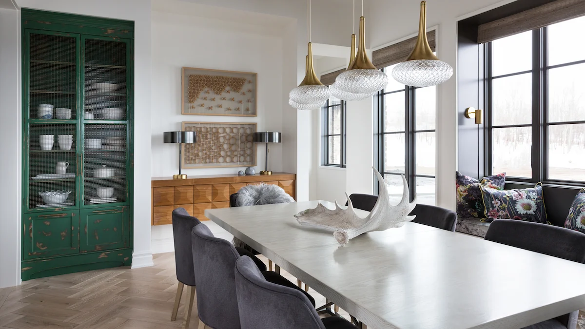 A built-in curio cabinet painted Kelly green with Floating walnut console in the dining room of a Rural Alberta Country House, Interior Design by Calgary Design Studio Nyla Free Designs Inc, Architecture: Dejong Design Associates, Photography: Phil Crozier #calgaryinteriordesign #calgaryinteriordesigner #nylafreedesigns #diningroominspirations #countryhouse