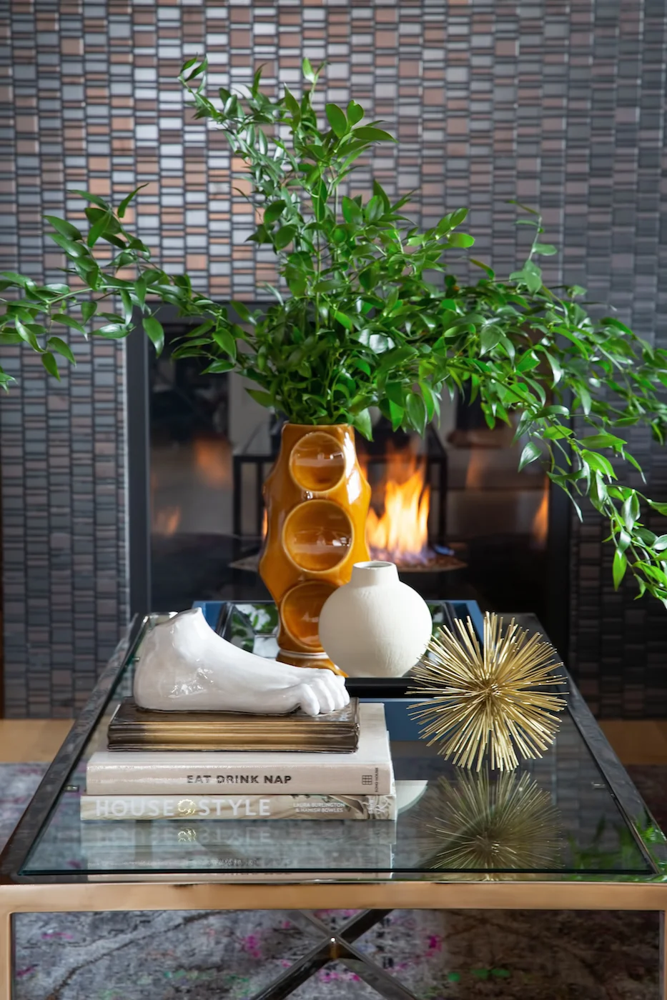 Detail shot of styled coffee table onlooking sitting room fireplace from an Elbow Park Residence, Interior Design by Calgary Design Studio: Nyla Free Designs, Photography: Phil Crozier #nylafreedesigns #nfdielbowparkluxe #sittingroomdesign #designinspirations