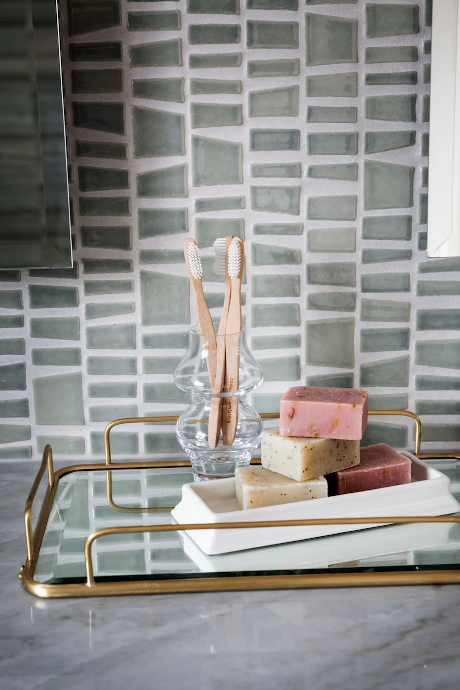 Detail shot of styled tray of the master ensuite featuring glass tile backsplash from an Elbow Park Residence, Interior Design by Calgary Design Studio: Nyla Free Designs, Photography: Phil Crozier #nylafreedesigns #nfdielbowparkluxe #masterensuited
