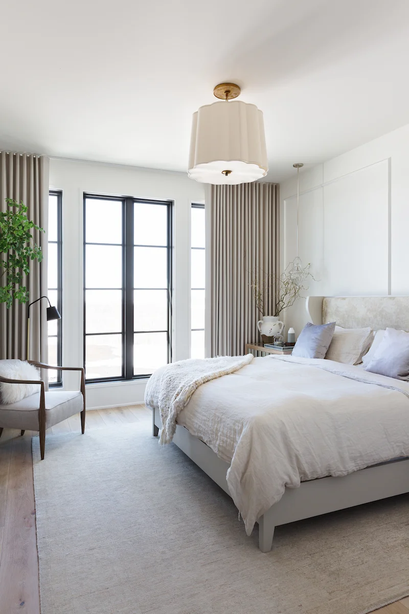 The neutral, light and airy master bedroom with wall panelling and pendant light from a Rural Alberta Country House, Interior Design by Calgary Design Studio Nyla Free Designs Inc, Photography: Phil Crozier #calgaryinteriordesign #calgaryinteriordesigner #nylafreedesigns #masterbedroominspirations #countryhouse