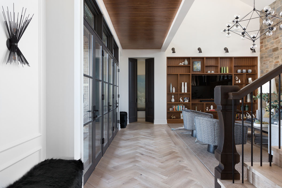 A light filled hallway with Herringbone Floors from a Rural Alberta Country House, Interior Design by Calgary Design Studio Nyla Free Designs Inc, Architecture: Dejong Design Associates, Photography: Phil Crozier #calgaryinteriordesign #calgaryinteriordesigner #nylafreedesigns #herringbonefloors #countryhouse