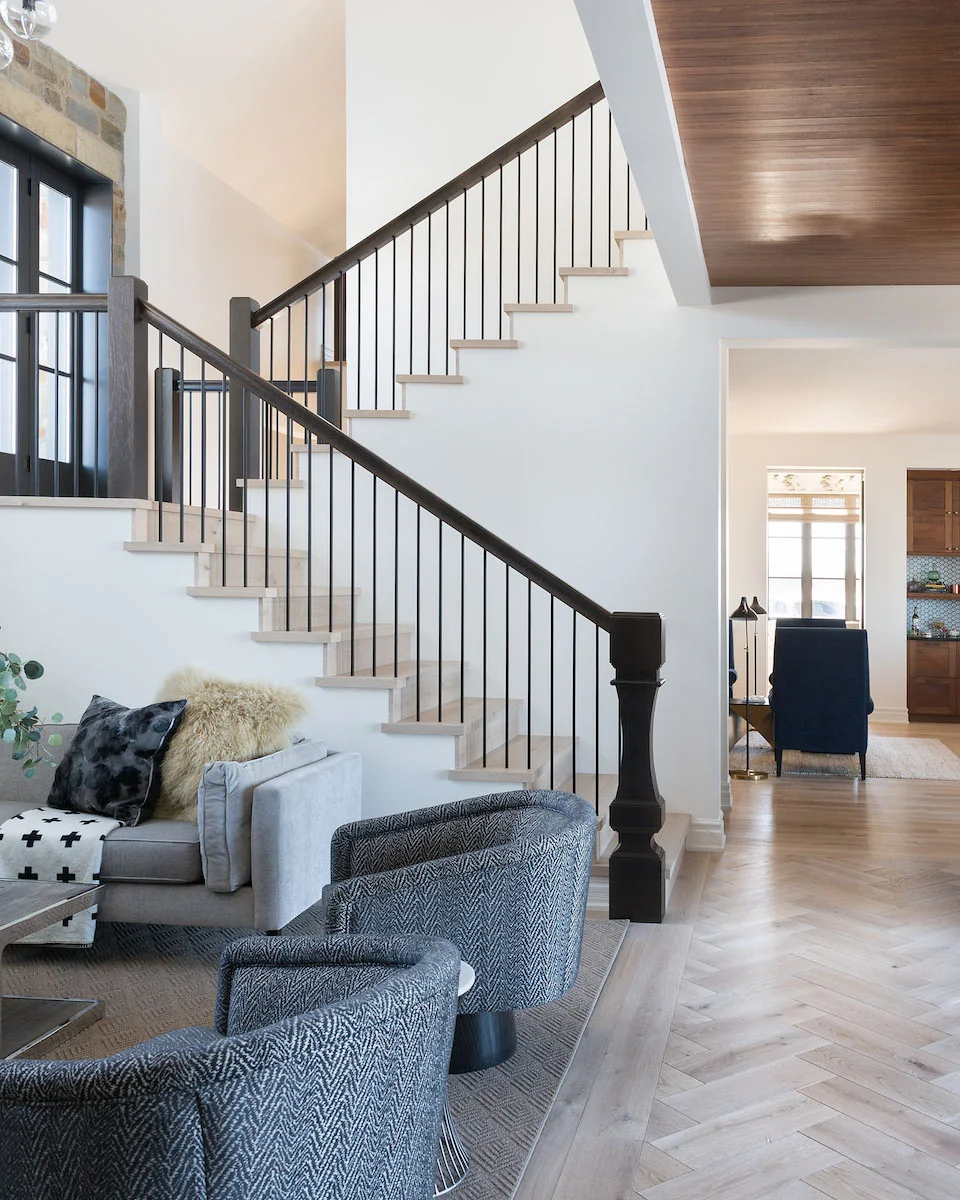 A light filled hallway with Herringbone Floors from a Rural Alberta Country House, Interior Design by Calgary Design Studio Nyla Free Designs Inc, Architecture: Dejong Design Associates, Photography: Phil Crozier #calgaryinteriordesign #calgaryinteriordesigner #nylafreedesigns #herringbonefloors #countryhouse