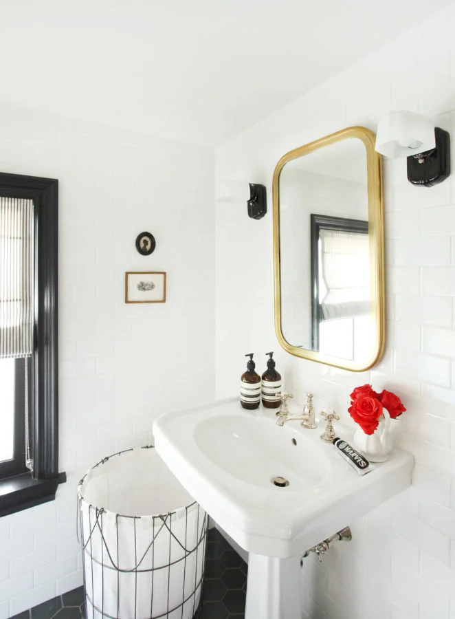 If you want a bathroom you don't have to remodel in 10 years, white subway tile will never go out of style. Black and brass accents make this monochromatic powder feel so clean and fresh.