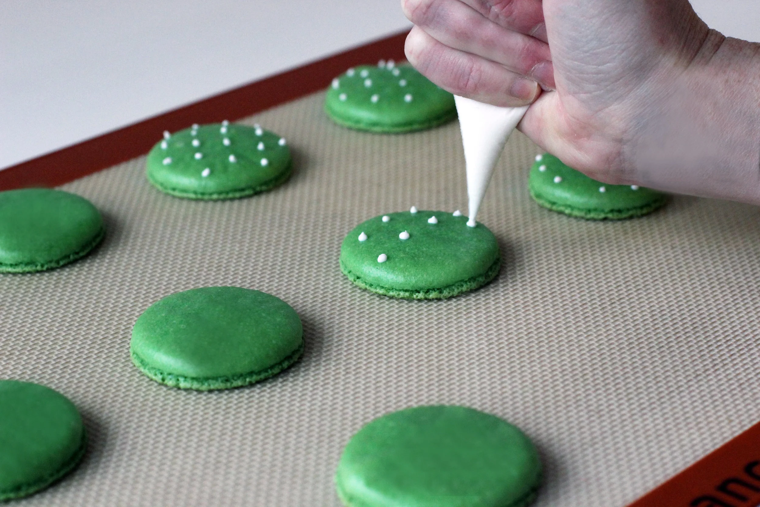 Step 2: Pipe spines onto larger and darker green macaron shells.