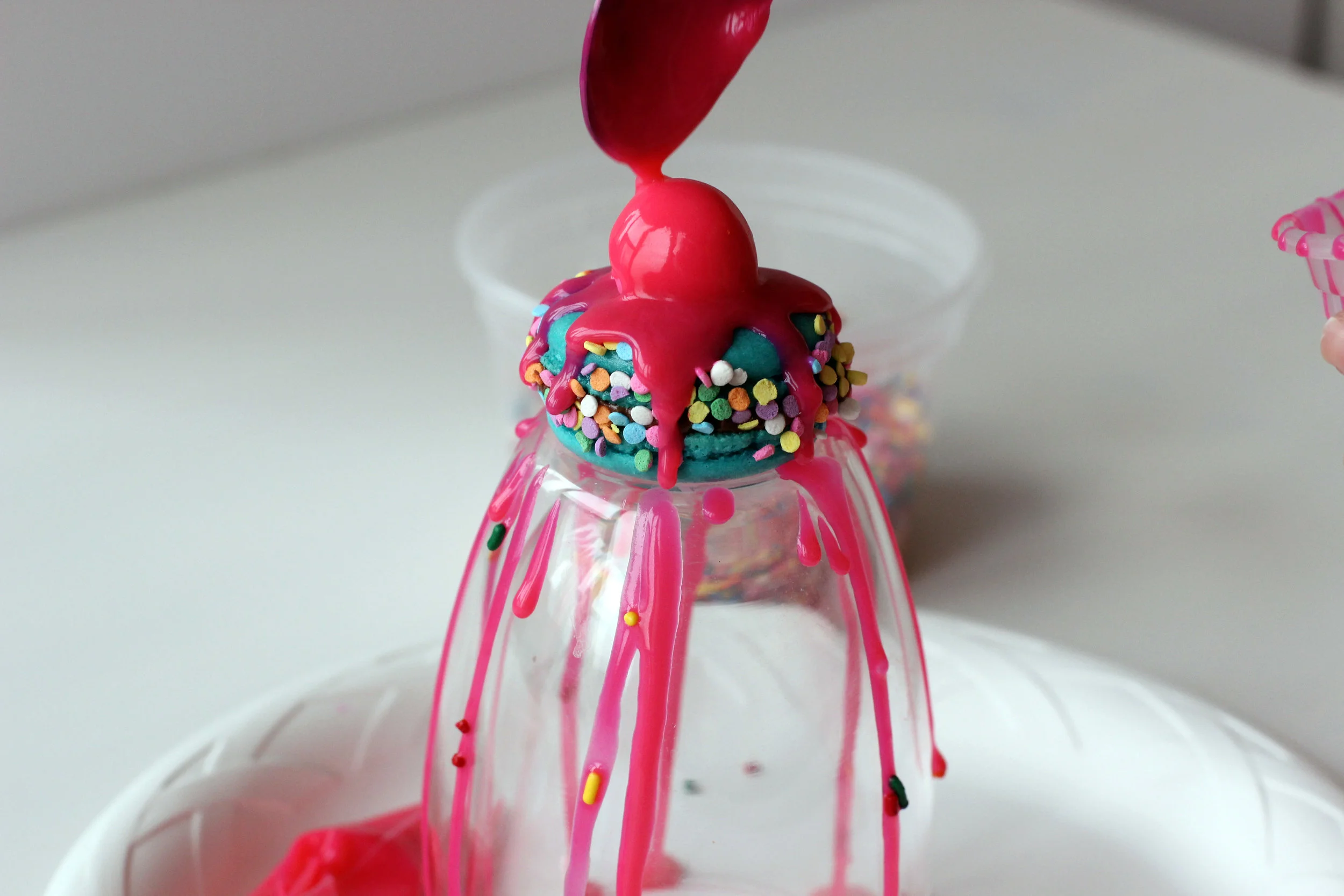 Step 6: Drizzle pink ganache over fondant cherry.