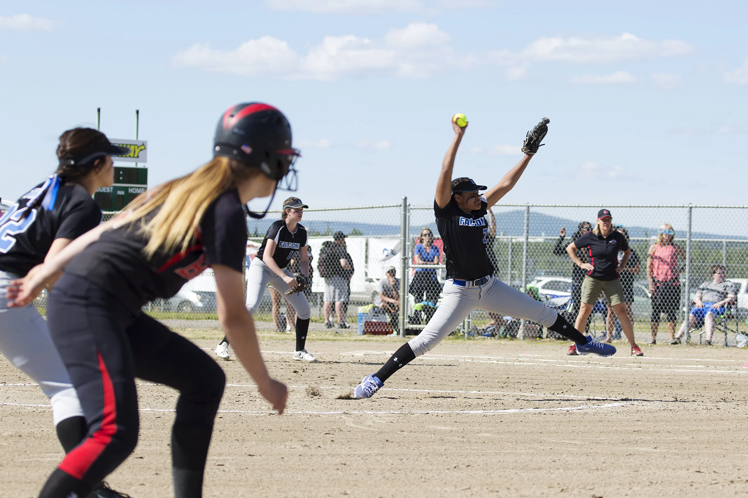 Thunder Mountain pitcher, Kyra Jenkins Hayes (7) (right) winds up for the pitch while Juneau Douglas, Elisa Fabrello (2) prepares to run to home base in the final game for the 2017 State Championship title on Saturday, June 3rd in the South Davis Pa…