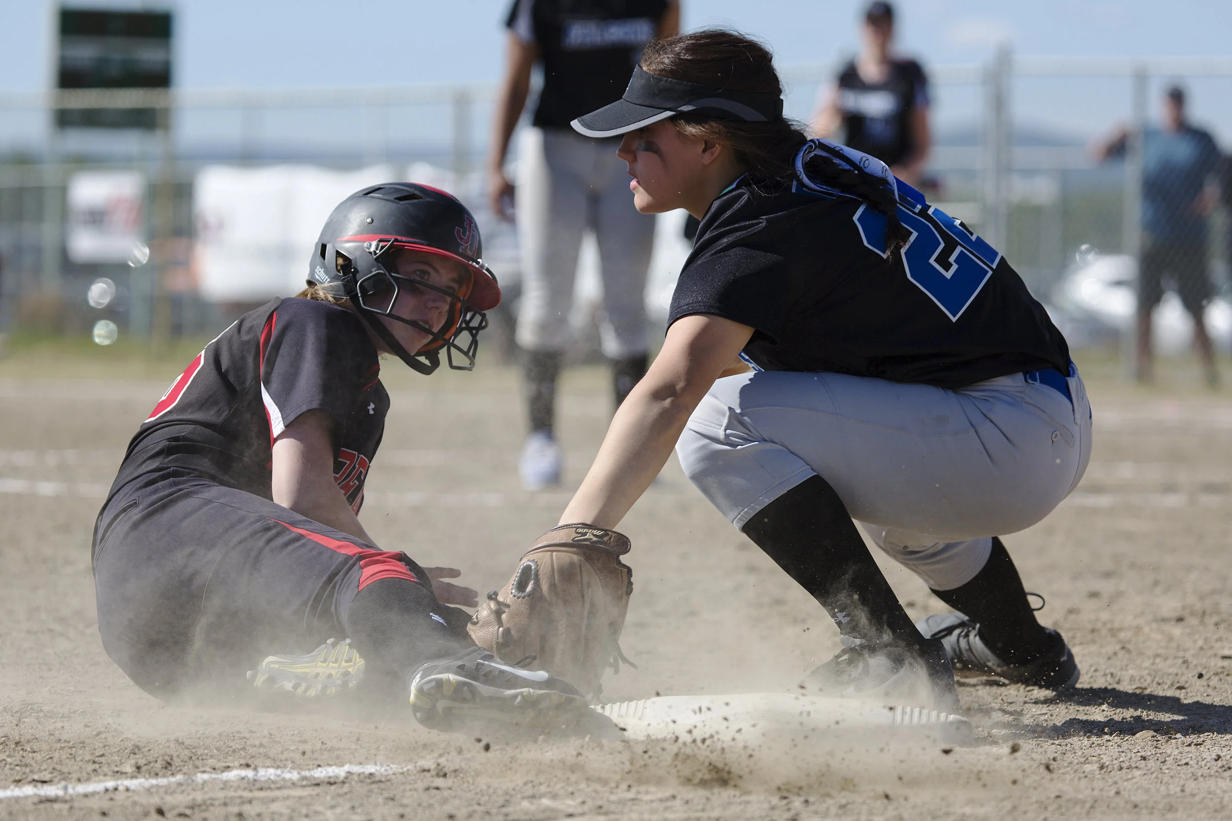 Juneau Douglas, Elisa Fabrello (2) (left) misses third base and is tagged out by Thunder Mountain, Alondra Echiverri (22) (right) who caught the ball moments before Fabrello slid onto the base in the finals for the State Championship Softball game o…