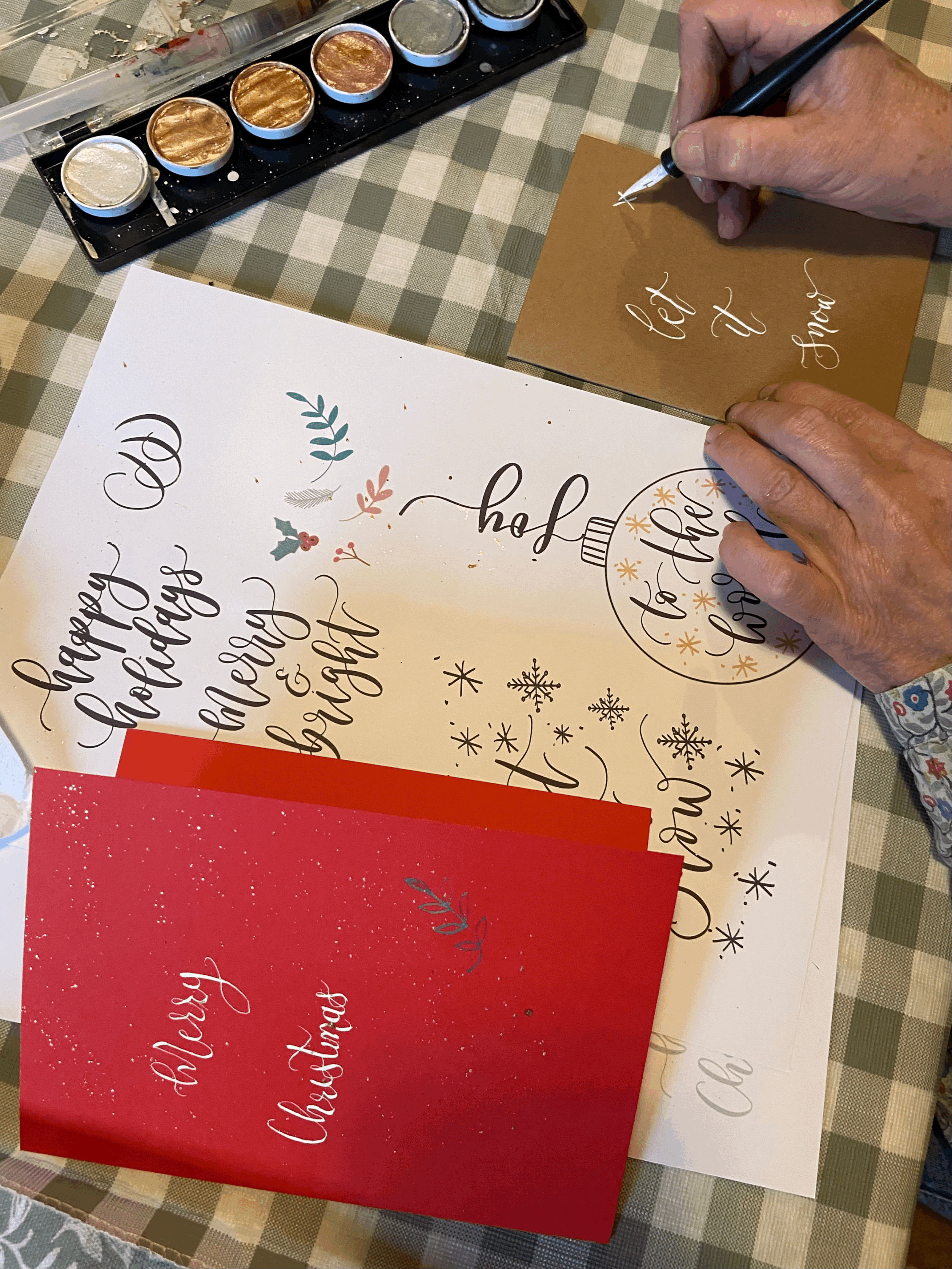 Modern calligraphy Christmas card with hand-lettered festive greeting, colourful inks and gold details